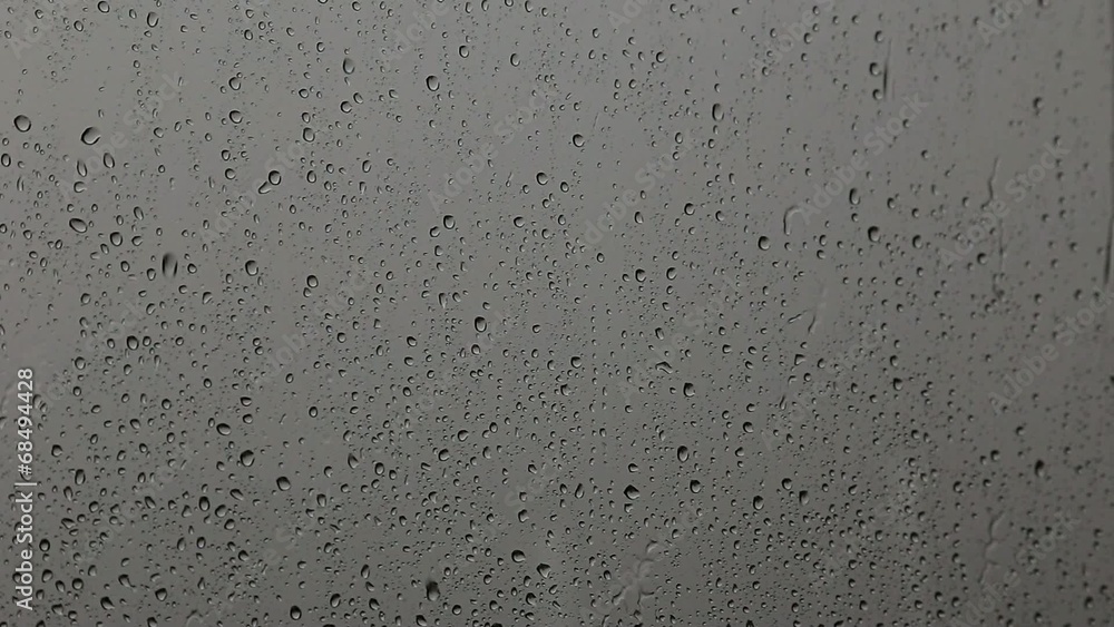 Water drops on glass. Rain splashing on the window pane Water drops on glass. Rain splashing on the window pane