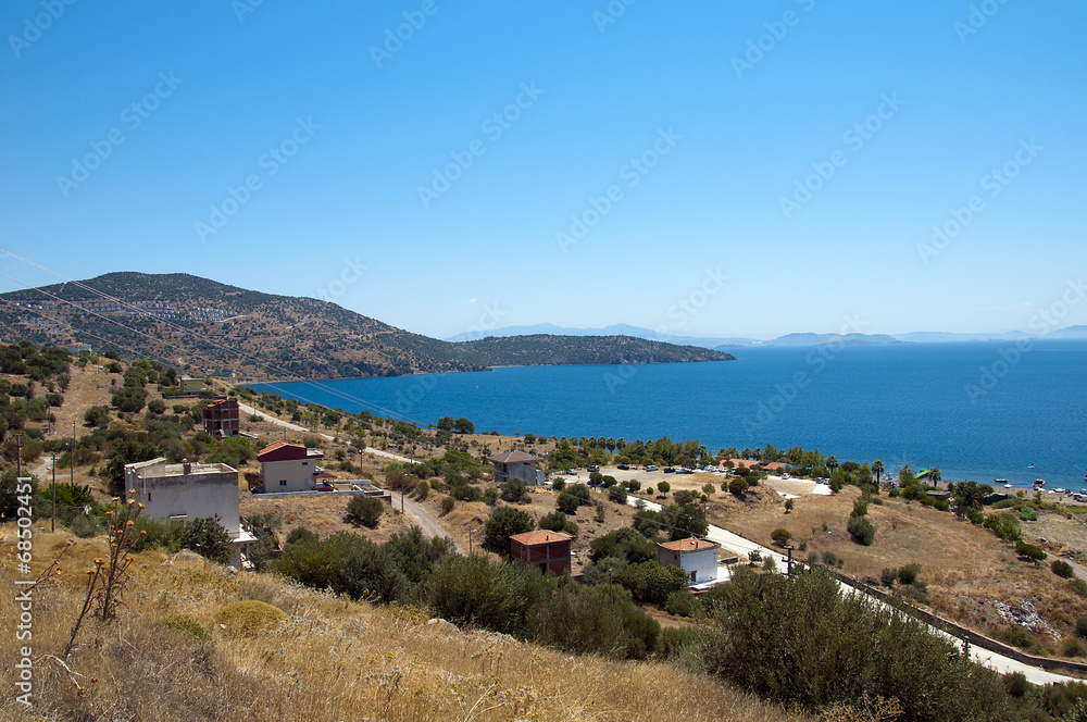 Aegean sea surrounded by hills on a sunny day