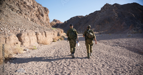Soldiers patrol in desert photo