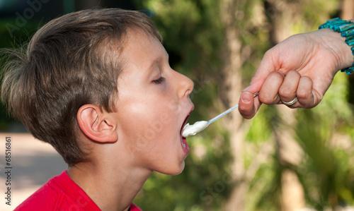 Young boy fed with spoon