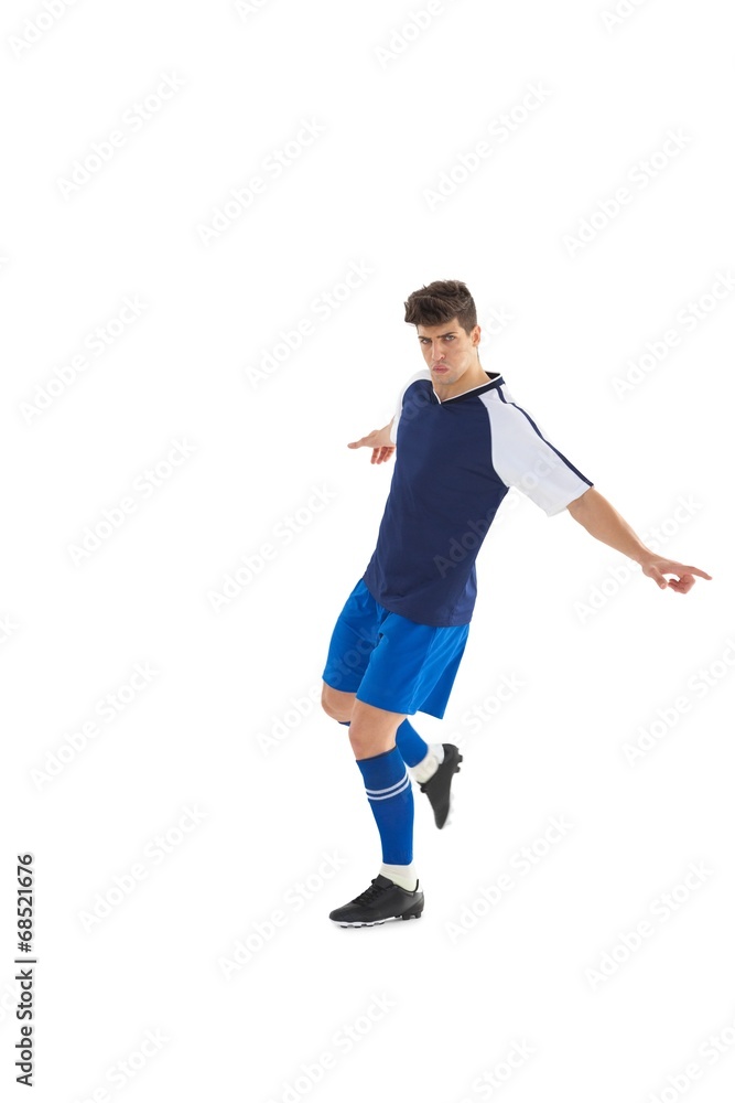 Football player in blue jersey kicking Football player in blue jersey kicking