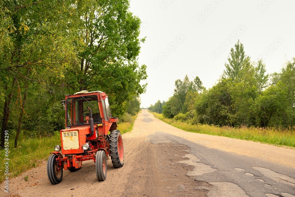 Old Russian tractor on gravel road Old Russian tractor on gravel road