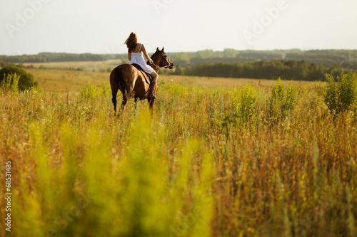 Girl jump on field on a horse
