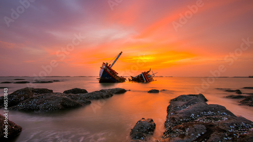 Fishing boat beached with sunset view photo