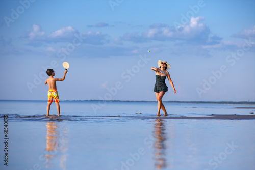 Young mother and son playing on the beach