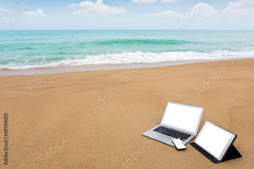 Laptop ,tablet and smartphone on the beach in summer time