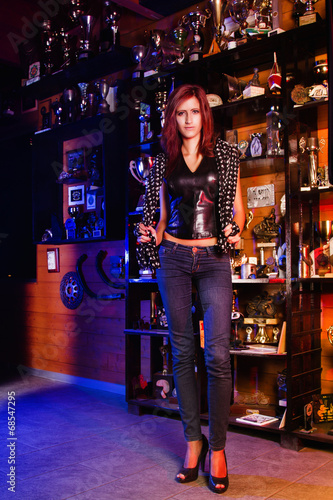  Biker girl standing in front of many trophies.