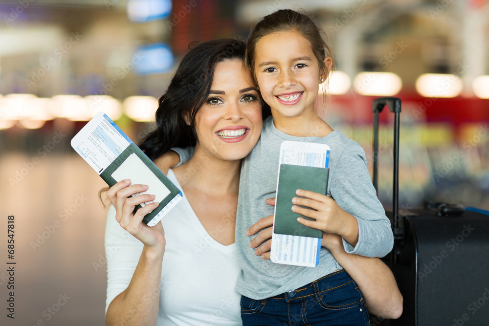 © michaeljung - mother and daughter holding passports and boarding pass
