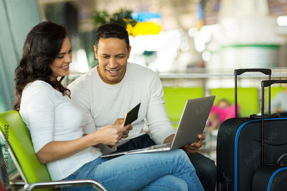 © michaeljung - couple checking flight information on laptop