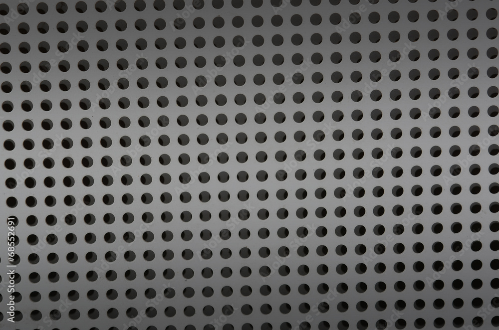 Background sheet of metal covered with lines of circular holes Background sheet of metal covered with lines of circular holes