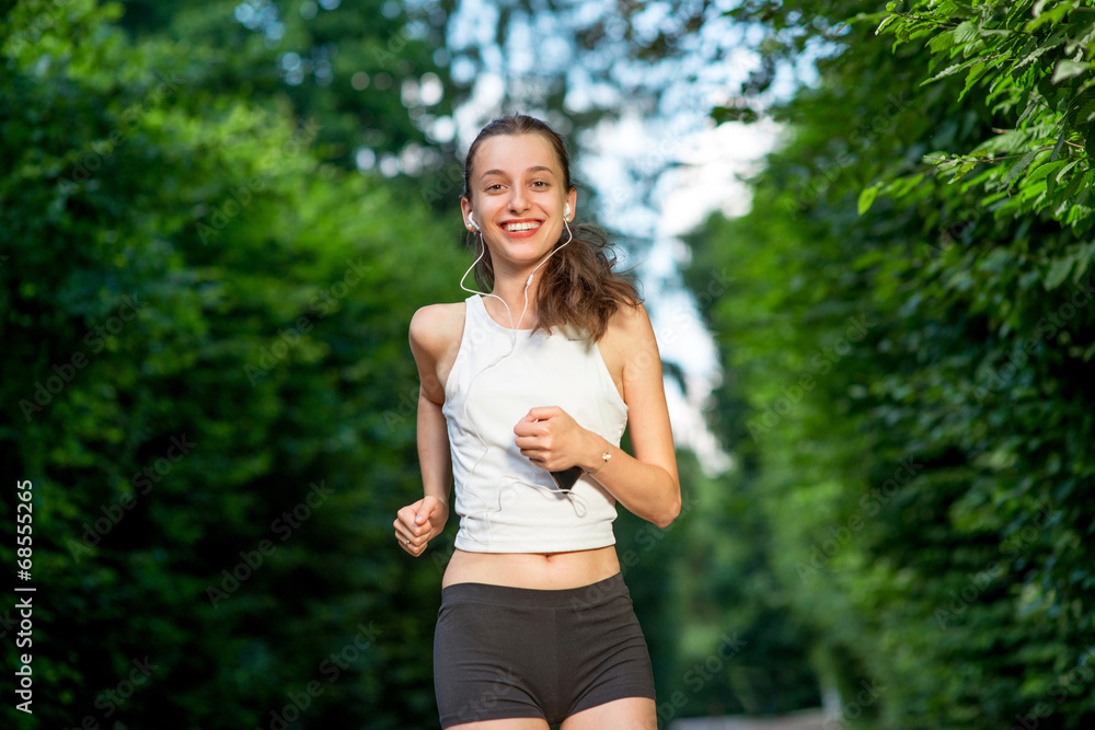 Running woman. Female runner jogging during outdoor workout in a Running woman. Female runner jogging during outdoor workout in a