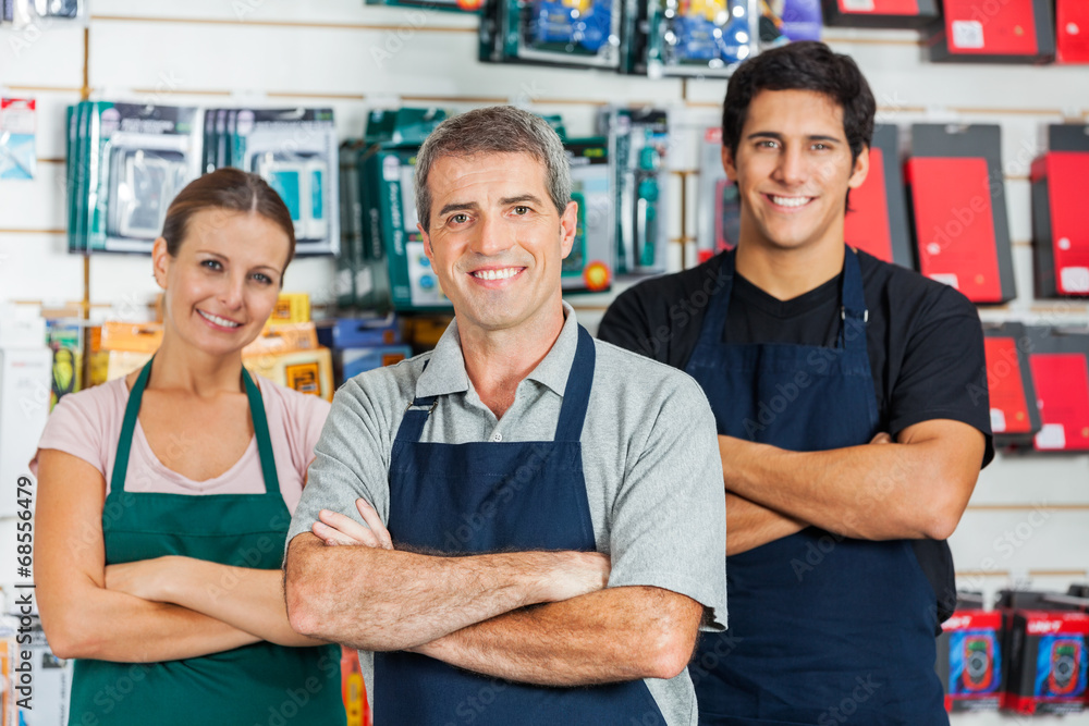 Salespeople Standing Arms Crossed In Hardware Shop