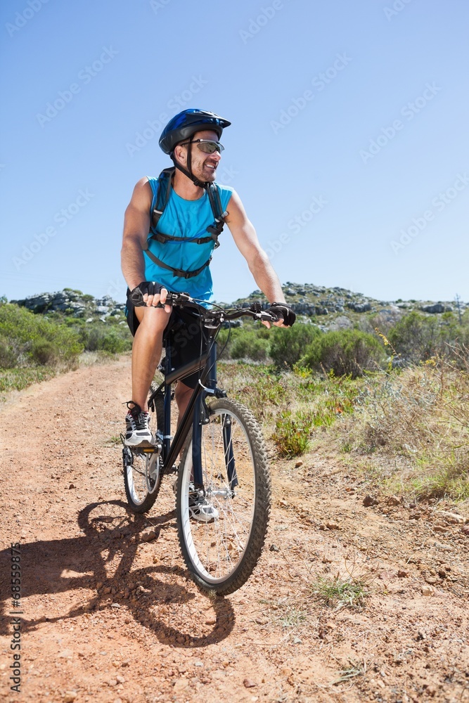 Fit cyclist riding in the countryside Fit cyclist riding in the countryside