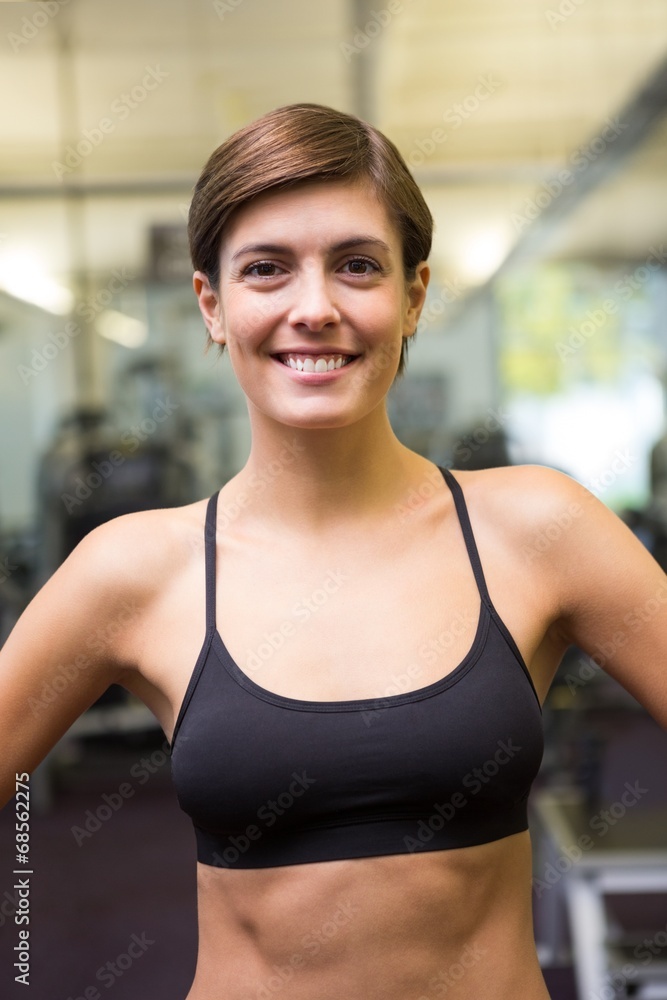 Fit brunette in black sports bra smiling at camera Fit brunette in black sports bra smiling at camera