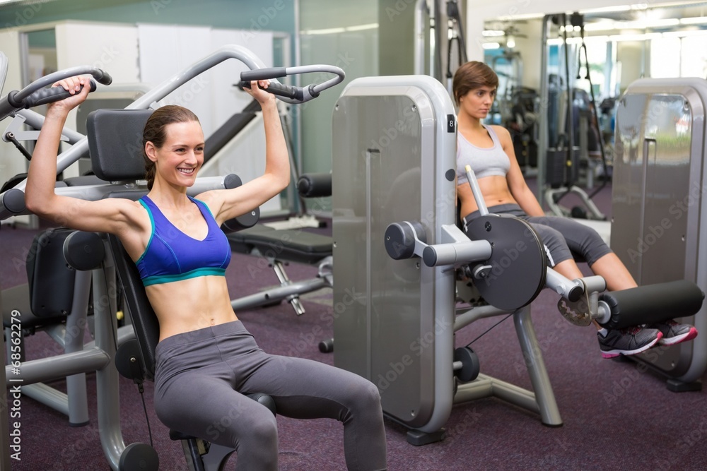 Healthy brunette using weights machine for arms Healthy brunette using weights machine for arms