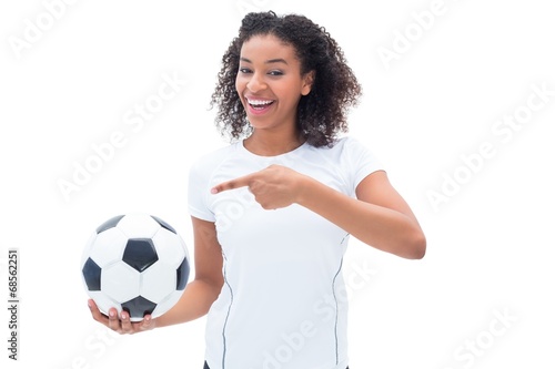 Pretty football fan in white holding ball and pointing to it © WavebreakmediaMicro