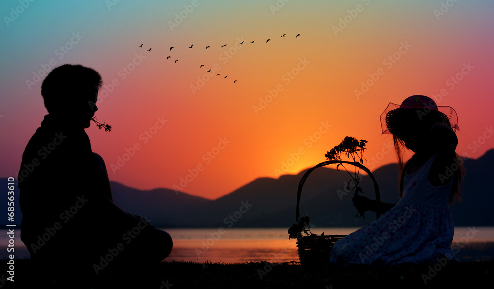 Fototapeta premium little boy and girl relaxing outside, silhouette