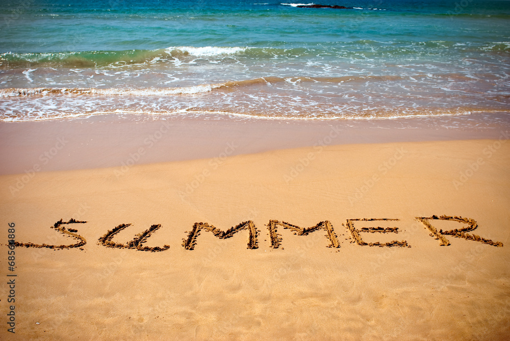 Fototapeta premium summer handwritten inscription in sand on a beach ocean