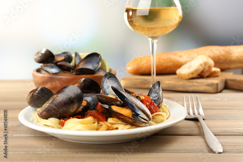 Tasty noodles with mussels on table, close up