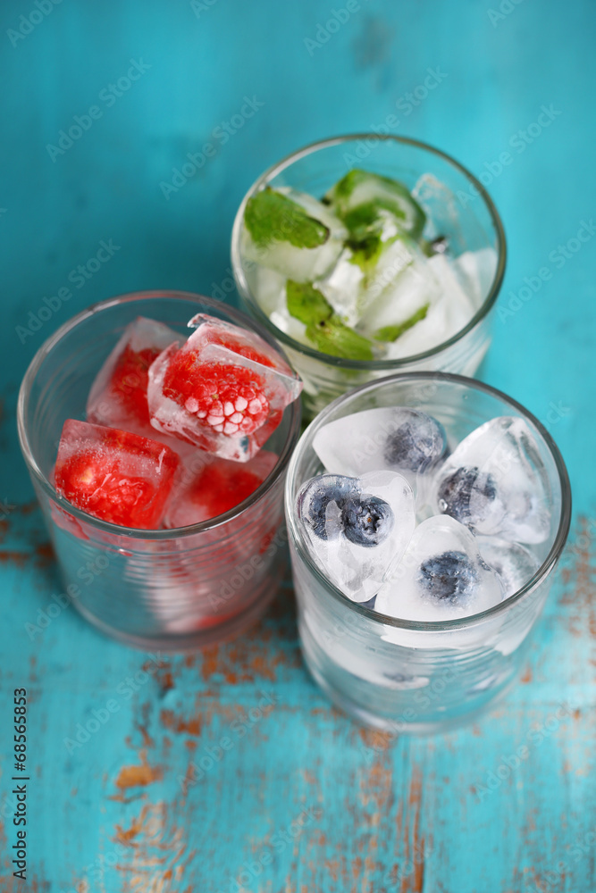 Ice cubes with mint leaves, raspberry and blueberry in glasses, Ice cubes with mint leaves, raspberry and blueberry in glasses,