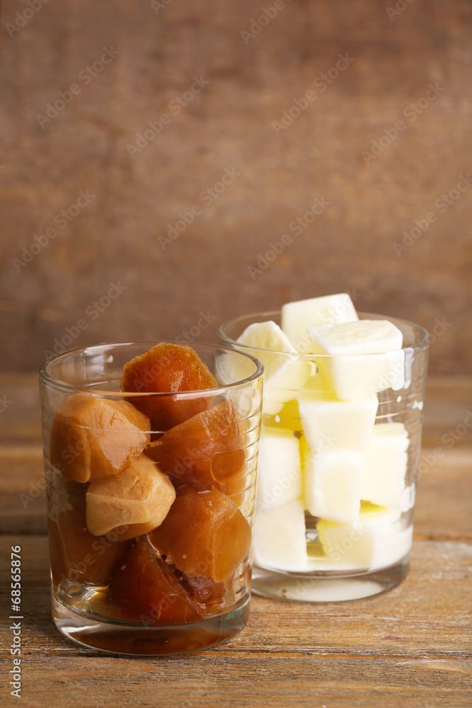 Iced coffee and milky cubes in glass on wooden background Iced coffee and milky cubes in glass on wooden background
