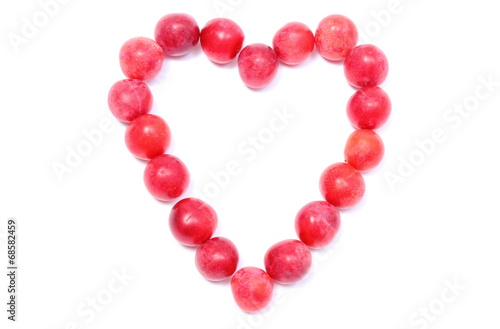 Heart of red mirabelle on white background