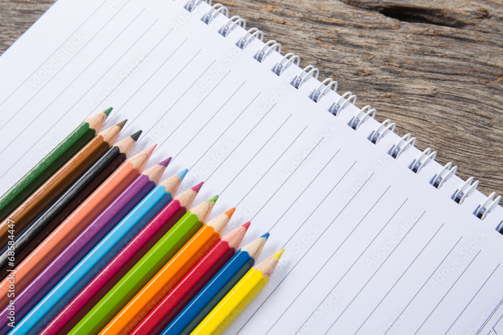 art, school, education, drawing and object concept - close up of crayons or color pencils on notebook paper art, school, education, drawing and object concept - close up of crayons or color pencils on notebook paper