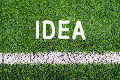 IDEA hand writing text on soccer field grass photo