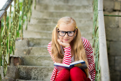 Children reading a book in the park outdoors photo