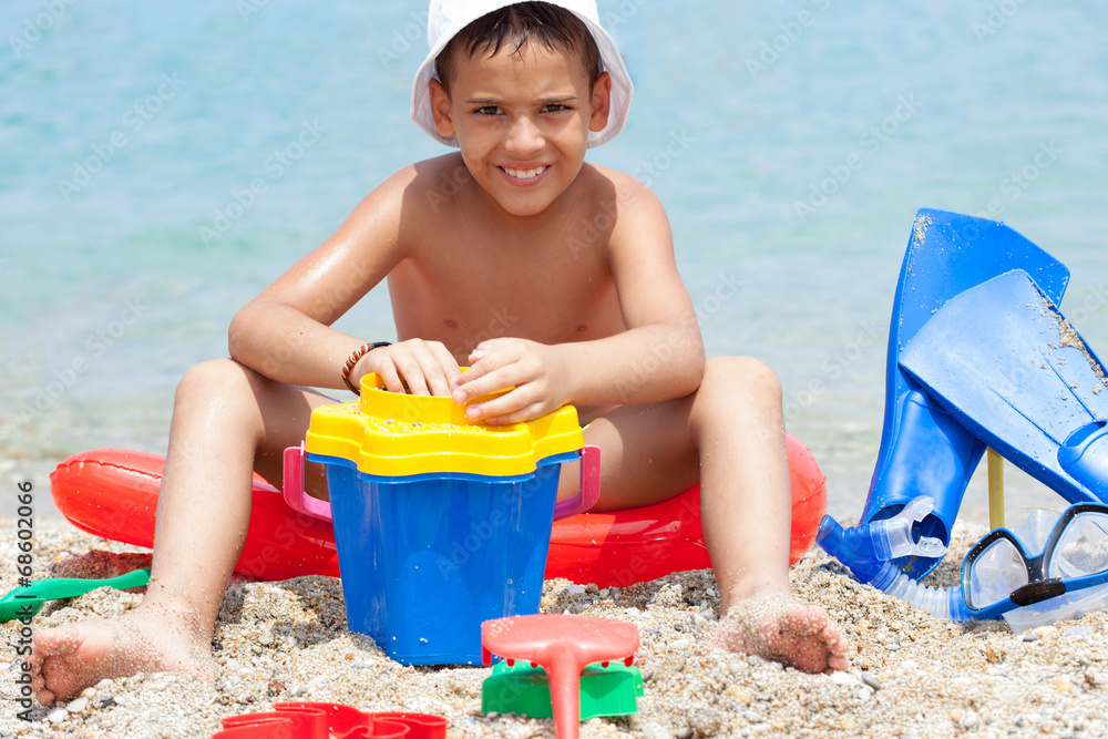 Little boy at tropical beach playing in the sand Little boy at tropical beach playing in the sand