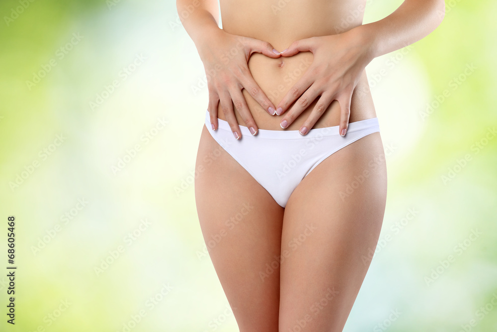 Woman's hands on stomach on green background Woman's hands on stomach on green background