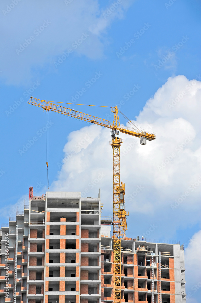 Crane and building construction site against blue sky Crane and building construction site against blue sky