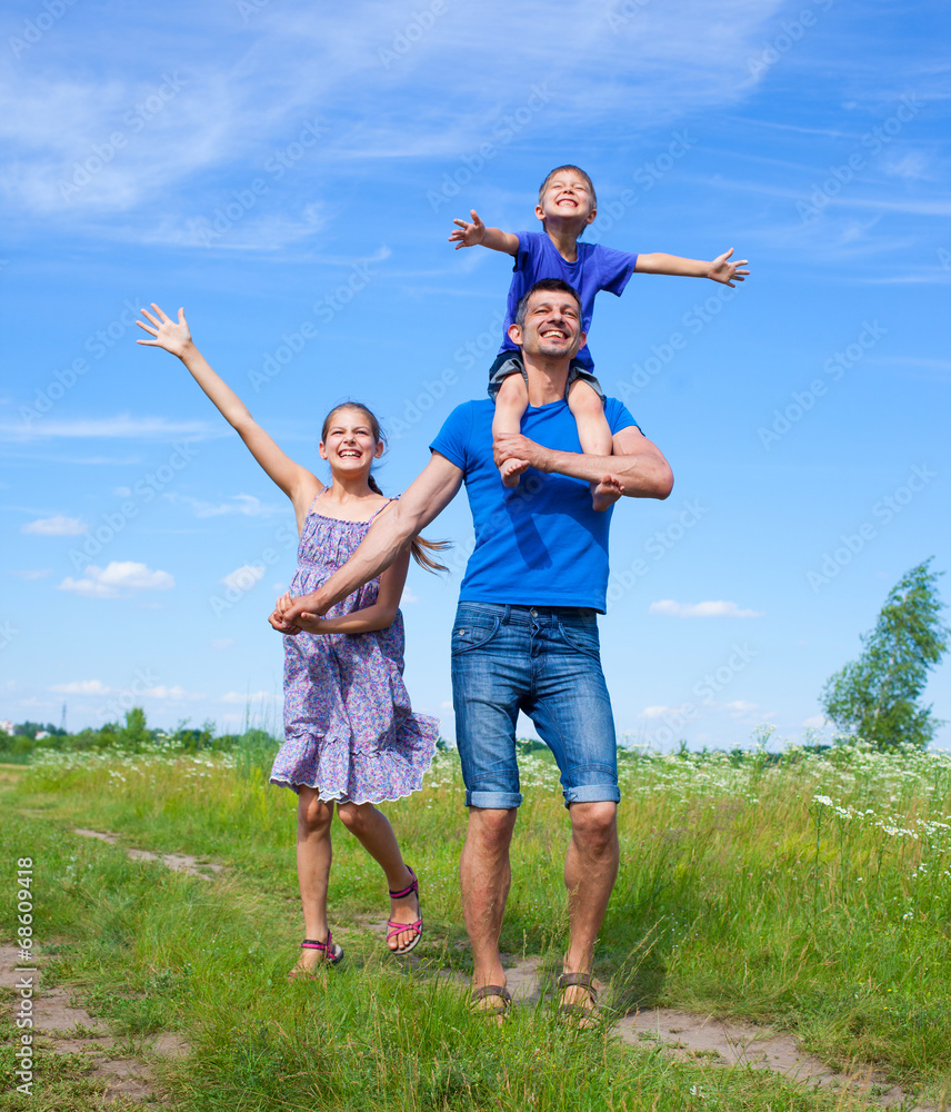 Happy father with kids outdoors against sky Happy father with kids outdoors against sky