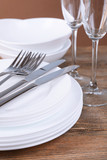 Set of white dishes on table on brown background