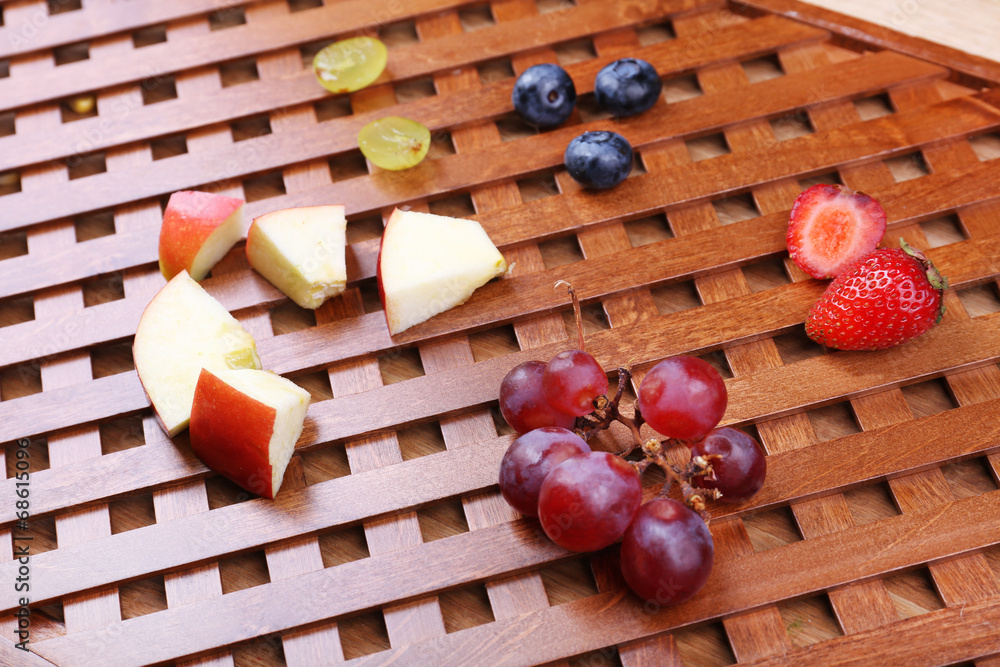 Different slices of fruits and berries on wooden table