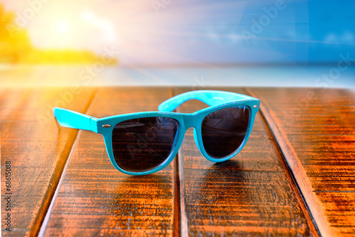 sunglasses on wooden desk at the beach. Summer vacation cincept. photo