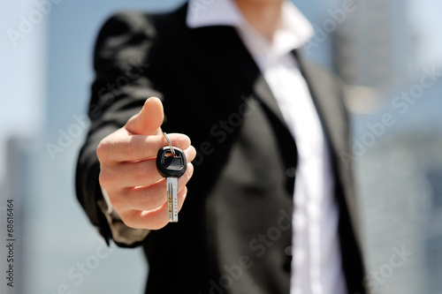 businessman holding a car key in his hand