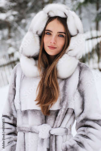 close-up portrait of smiling girl in fur hood in winter city