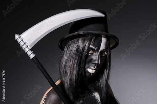 Woman in halloween concept with scythe © Elnur