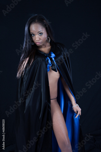 Black woman in black cape, looking with friendly expression