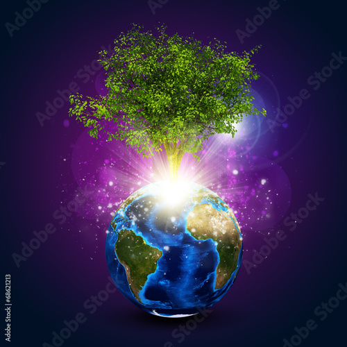 Earth with magical green tree and rays of light