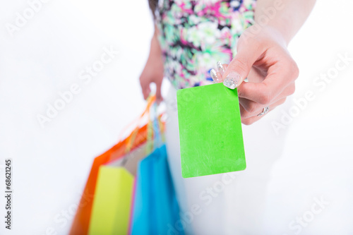 young woman with shopping bags and credit card on a white backgr