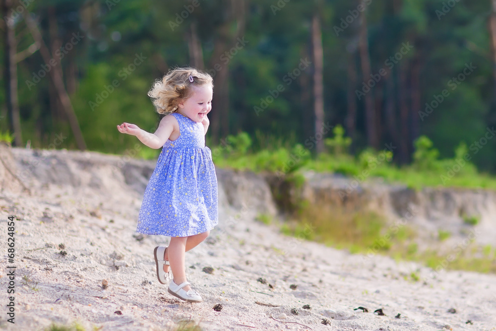 Little girl running in a pine forest Little girl running in a pine forest