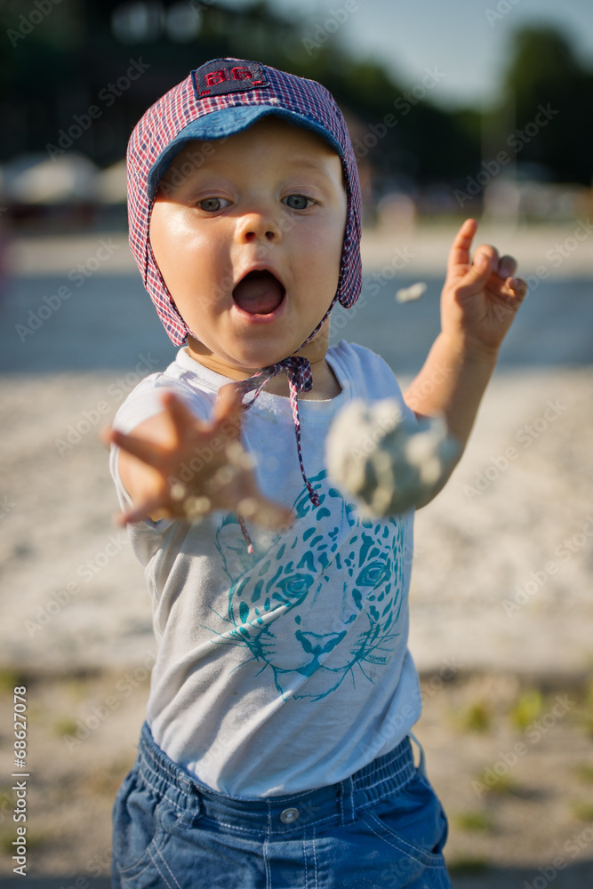 A two year old boy throwing a sand ball A two year old boy throwing a sand ball