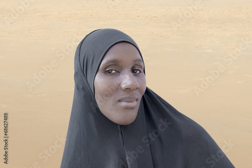 African woman wearing a black cotton veil in the desert photo