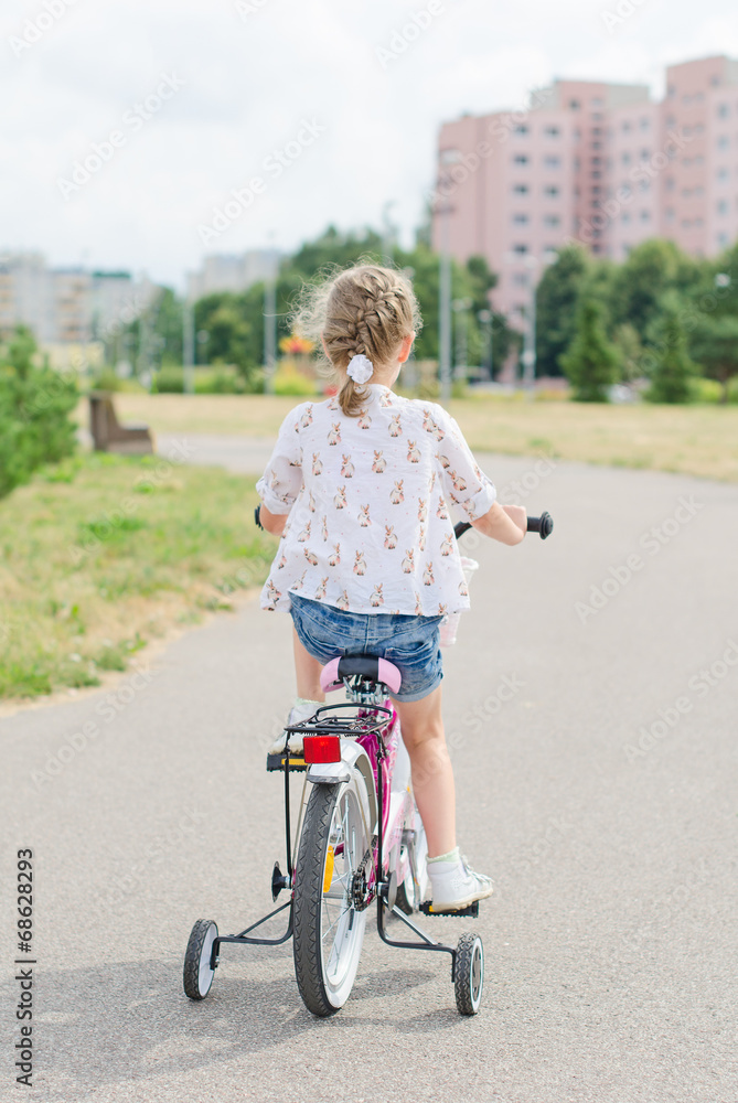 Little girl riding a bicycle in the park.