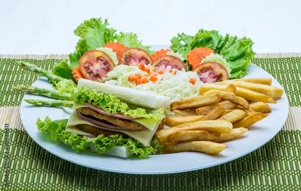 chicken sandwich on a white plate with french fries.