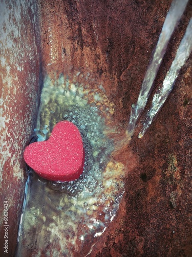 Cuore di spugna con acqua che scorre photo