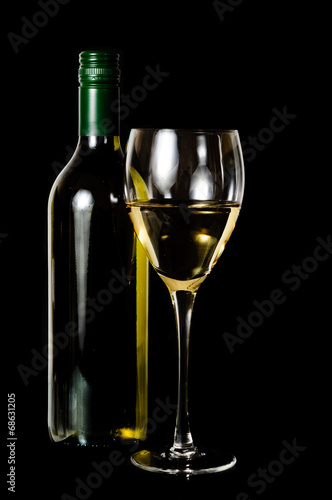 A glass and green rit bottle of white wine