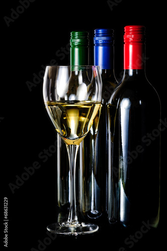 Elegant glass of white wine  and  wine bottle